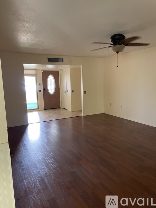 A room with wooden floors and a ceiling fan.