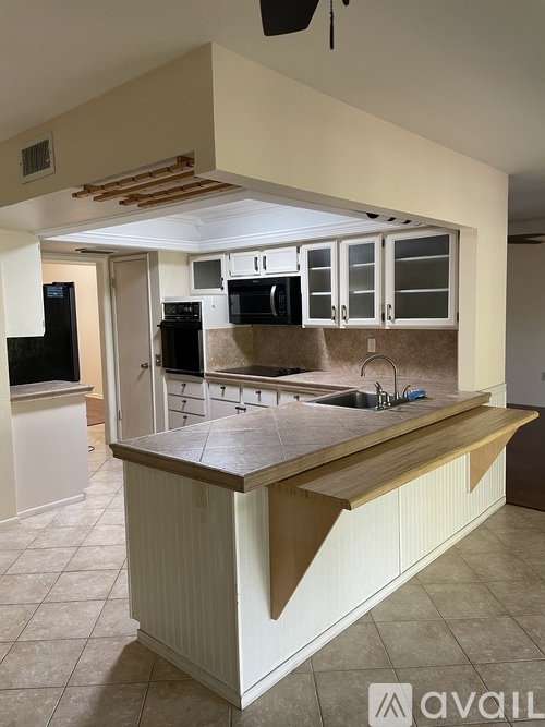 A kitchen with a white counter and brown cabinets.