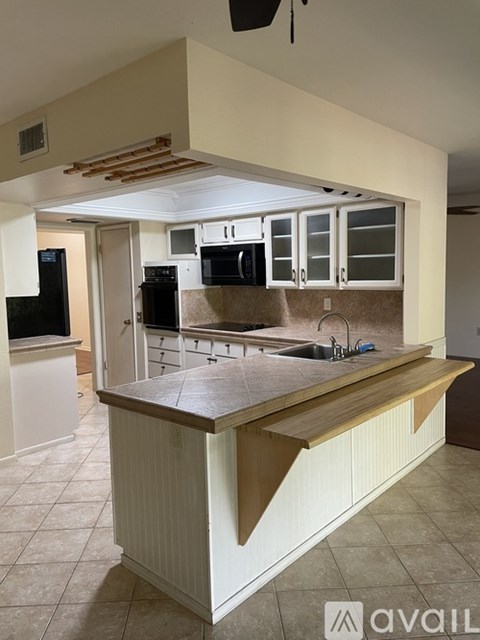 A kitchen with a white counter and brown cabinets.
