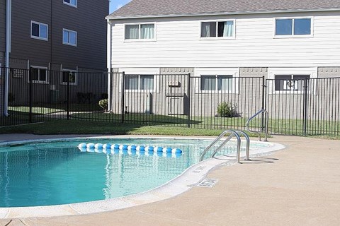 A pool with a ladder in front of a building.