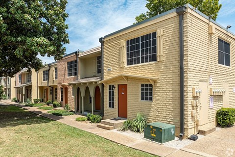 A row of houses with a green container in front of the first one.