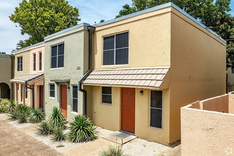 A row of houses with different colored front doors.
