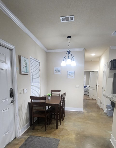 A dining room with a table and chairs.