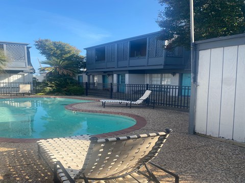 A chair is in the foreground of a pool area.