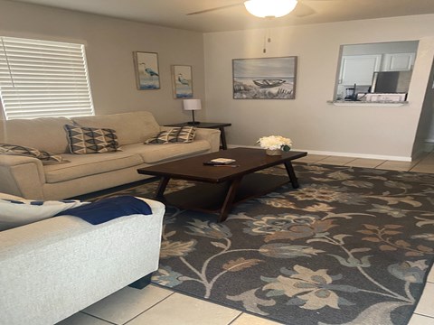A living room with a couch, coffee table, and pictures on the wall.