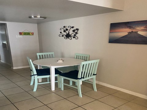 A dining room with a white table and chairs.