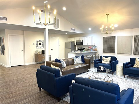 A living room with blue couches and a chandelier.