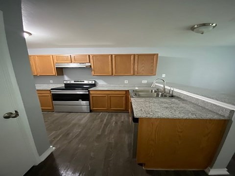 A kitchen with wooden cabinets and a stainless steel dishwasher.