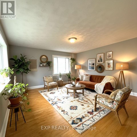 A living room with a brown sofa, a wooden coffee table, and a rug with a floral pattern.