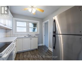 A kitchen with white cabinets and a stainless steel refrigerator.