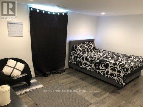 A bedroom with a black and white bed and a black chair.
