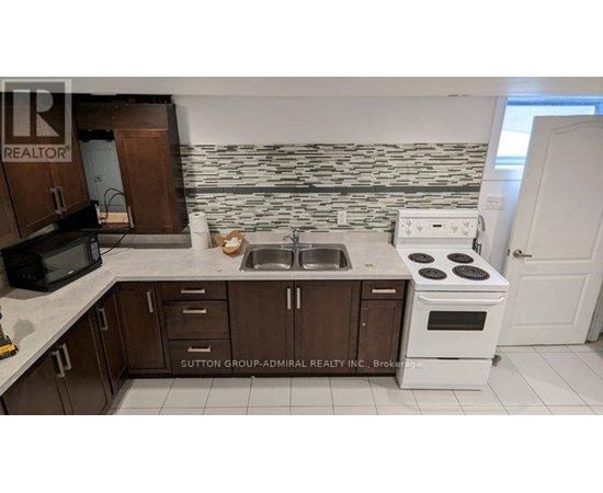 A kitchen with a white stove and brown cabinets.