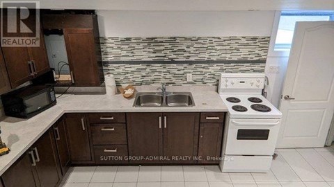 A kitchen with a white stove and brown cabinets.