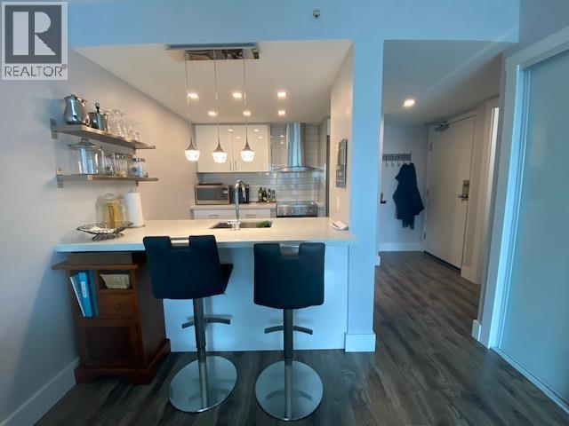 A kitchen with a bar area and two stools.