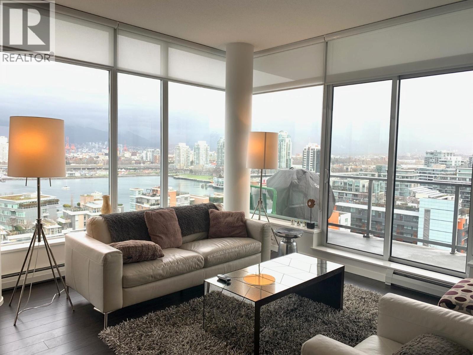 A living room with a large window overlooking a cityscape.