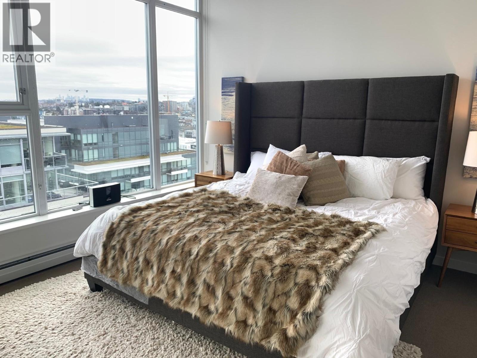 A bedroom with a large bed and a view of the city.
