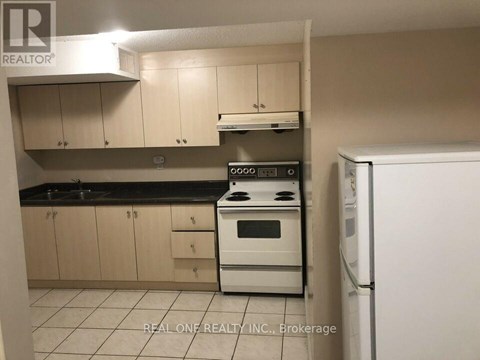 A kitchen with a white stove top oven and a white refrigerator.
