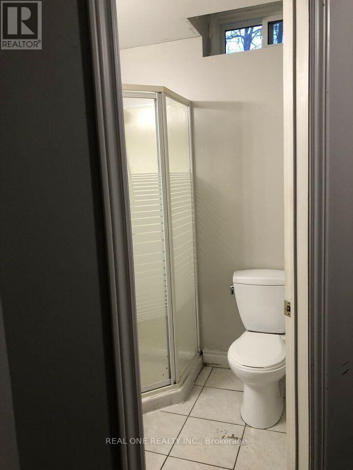A white toilet in a small bathroom with a glass shower door.