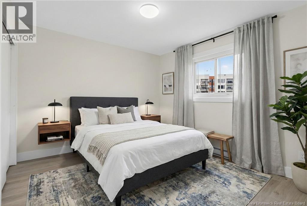 A bedroom with a large bed and a window with curtains.