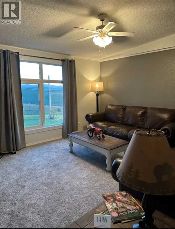 A living room with a brown leather couch and a ceiling fan.