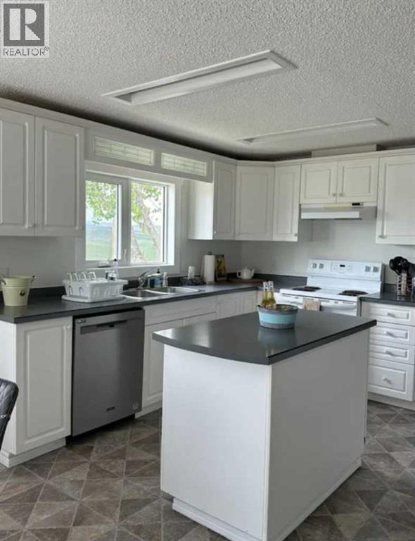 A kitchen with white cabinets and a black countertop.