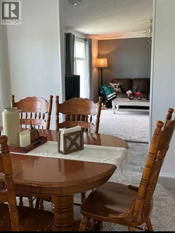 A dining room with a wooden table and chairs.