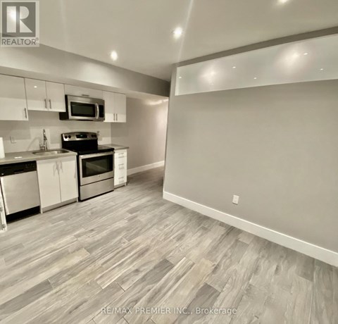 A kitchen with a microwave above the stove and a counter with a sink.