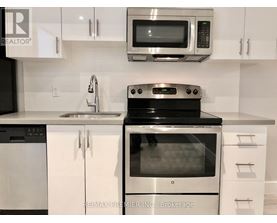 A modern kitchen with white cabinets and stainless steel appliances.
