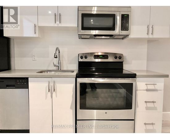 A modern kitchen with white cabinets and stainless steel appliances.