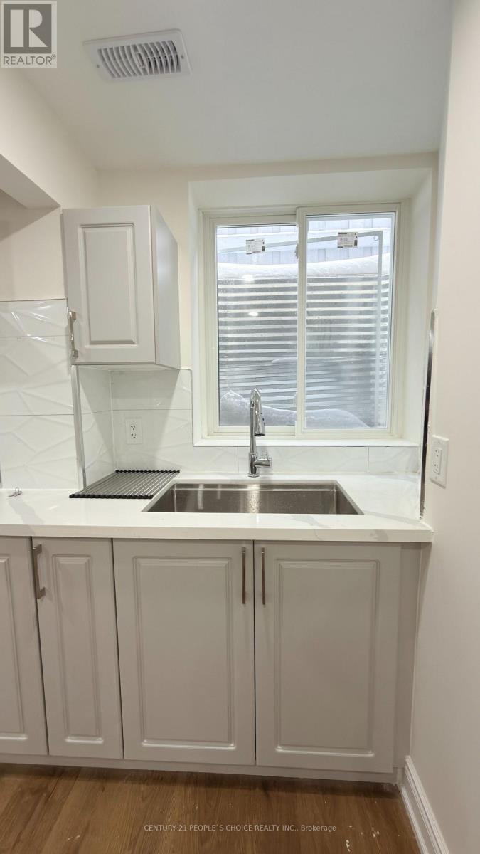 A white kitchen with a sink and cabinets.