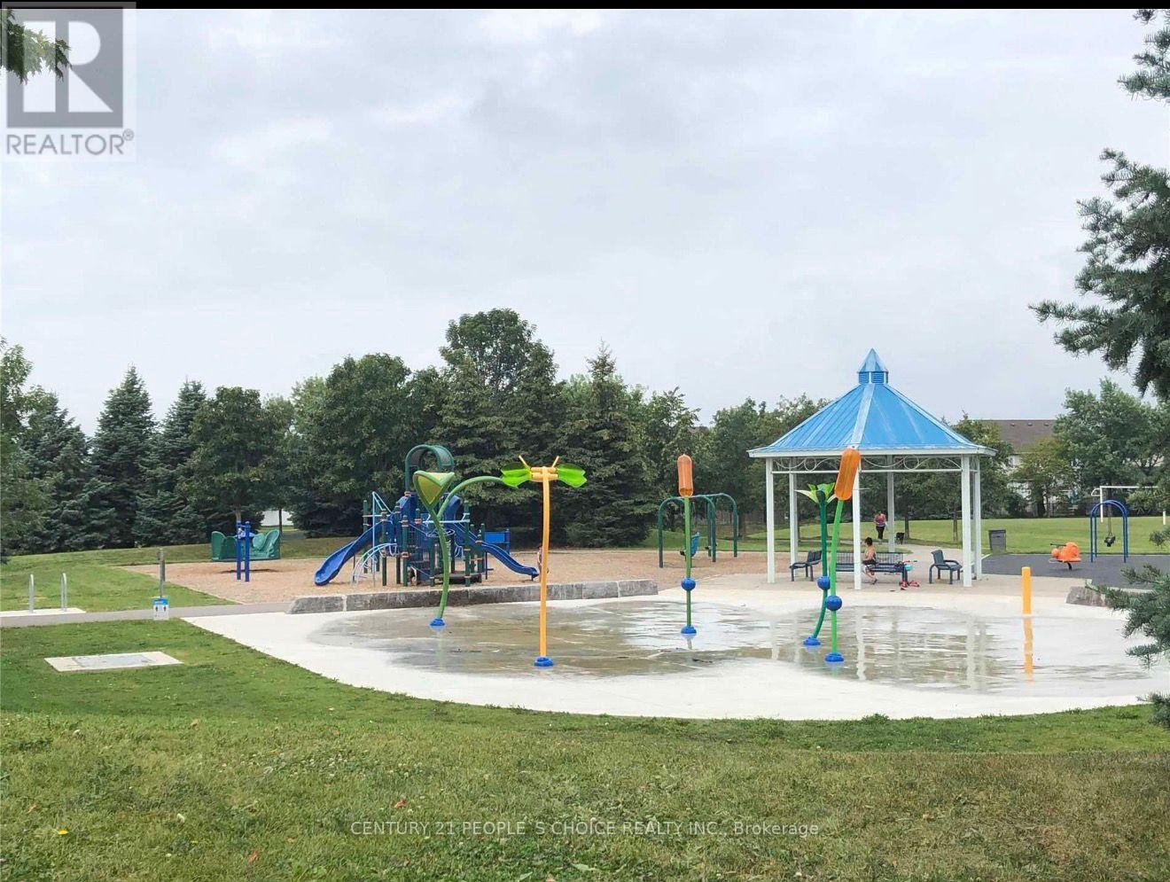 A playground with a blue and white structure and a green slide.