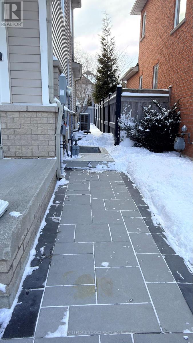 A snow-covered sidewalk in front of a house.