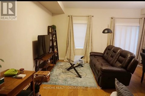 A living room with a brown leather couch and a wooden coffee table.