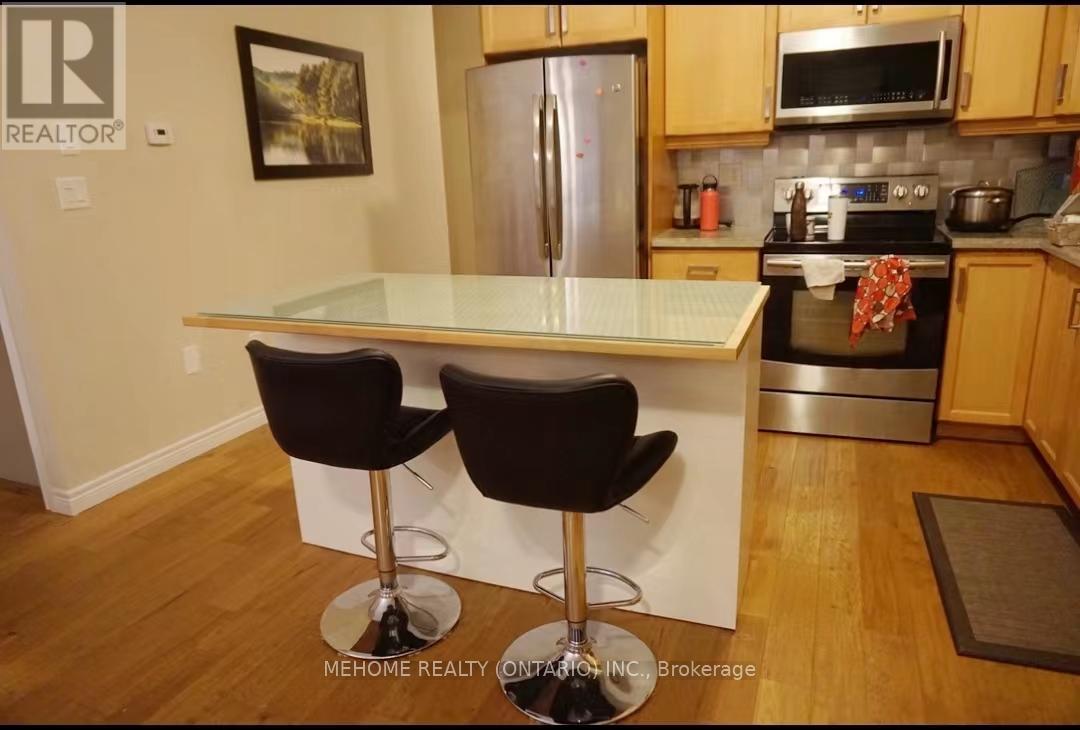 A kitchen with a white counter top and two black bar stools.