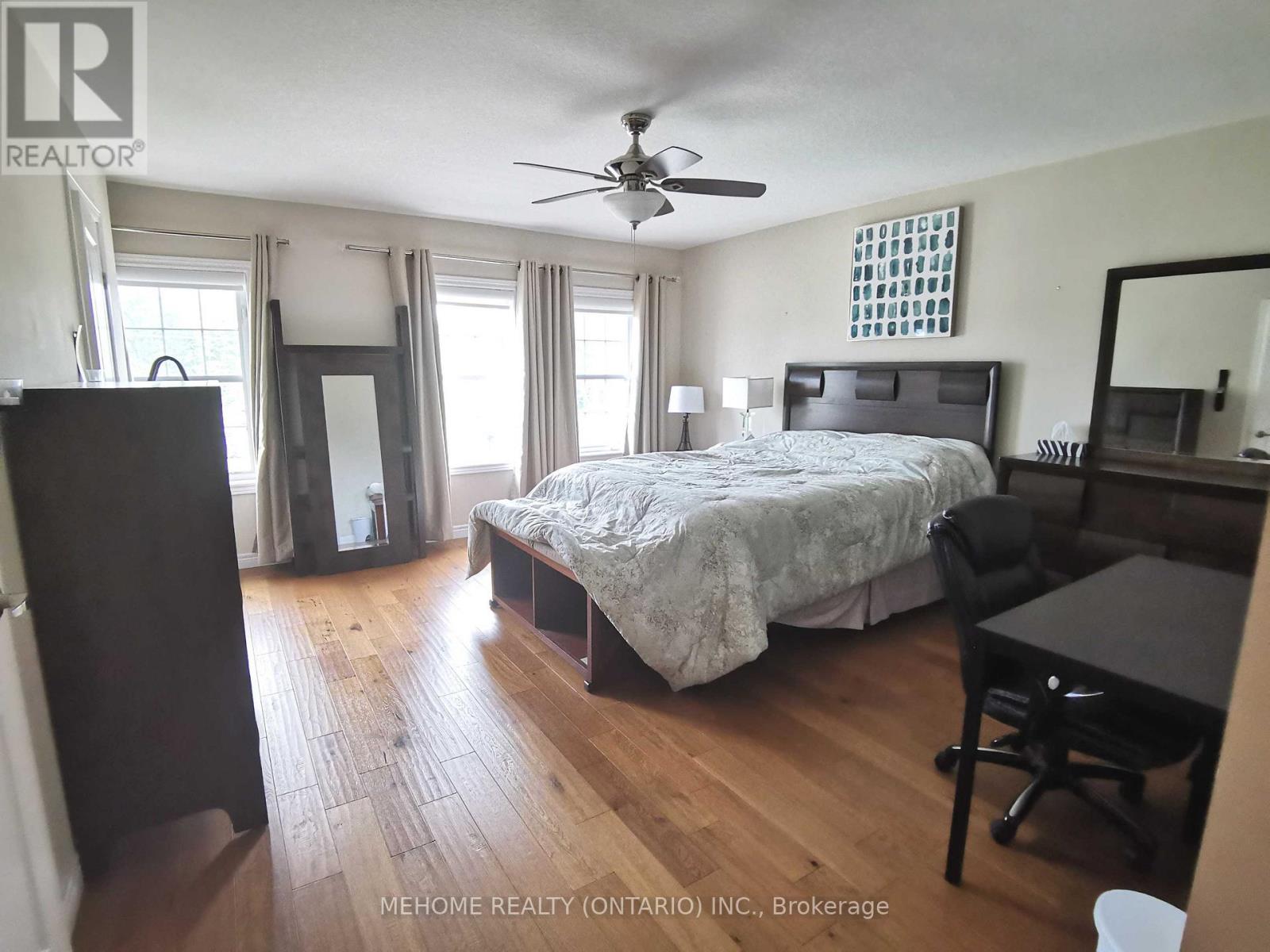 A bedroom with a bed, desk, and chair.