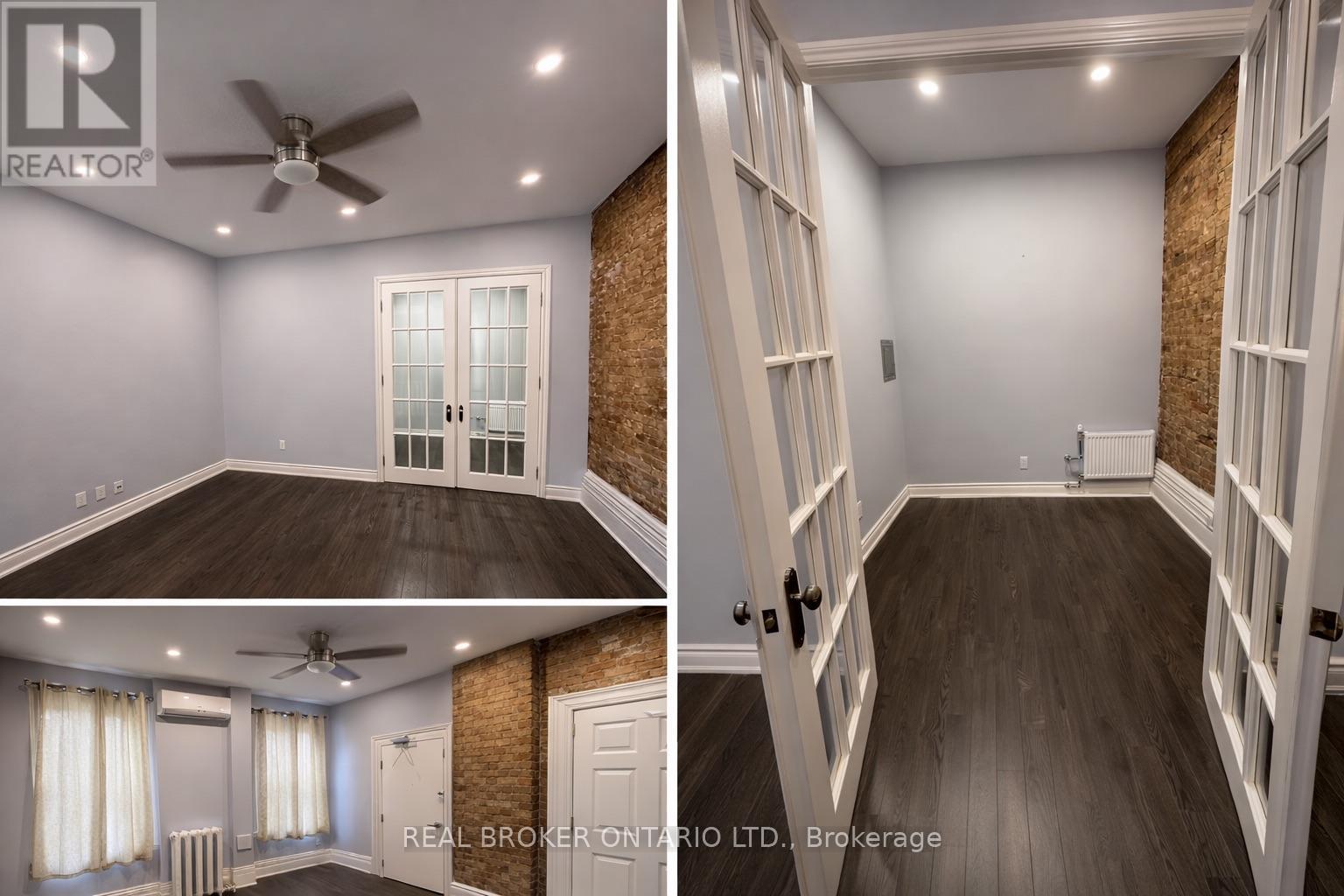 A real estate broker's office with a ceiling fan and a brick wall.