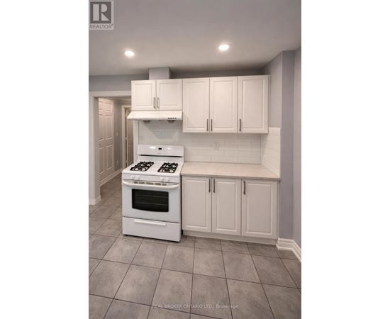 A white kitchen with a stove and cabinets.
