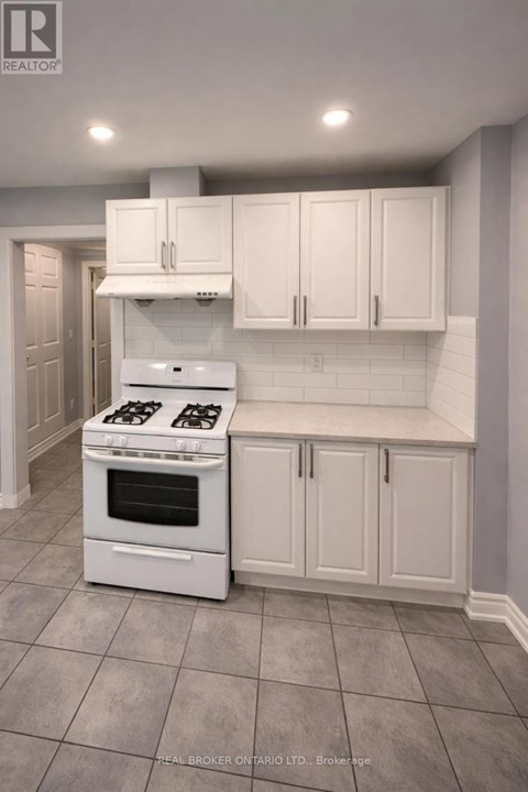 A white kitchen with a stove and cabinets.