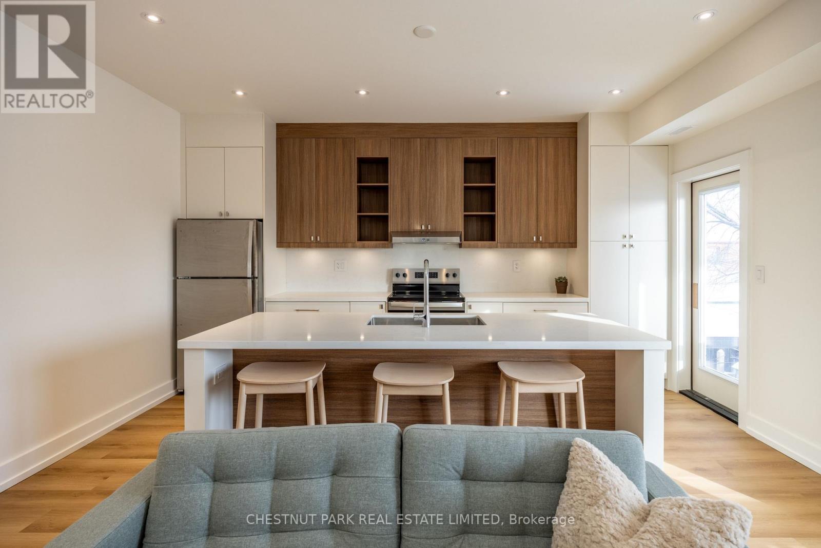A modern kitchen with wooden cabinets and a white island.