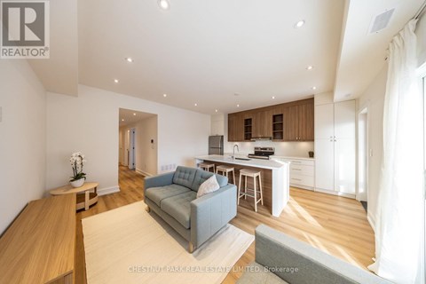 A modern living room with a grey sofa and wooden floors.