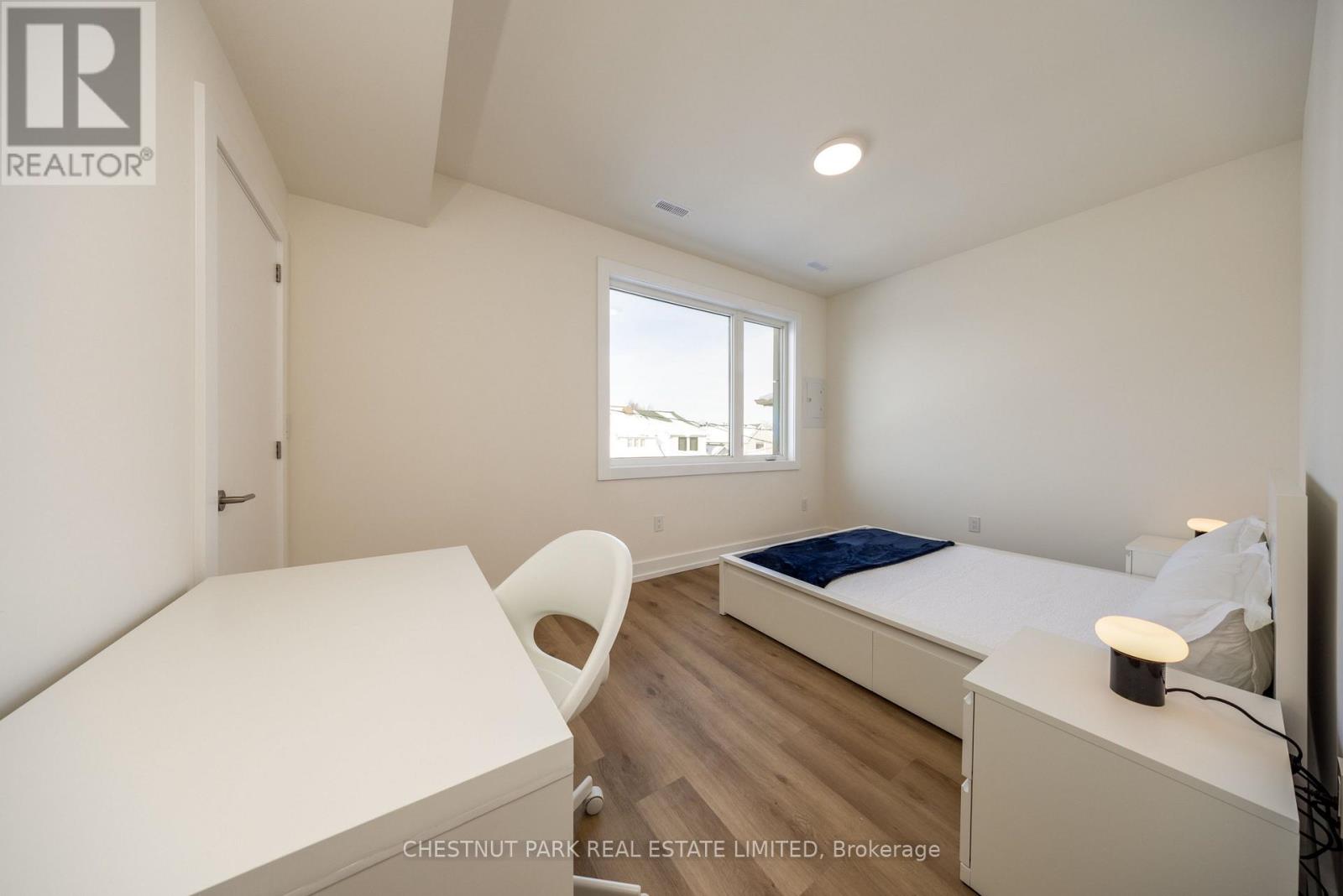 A bedroom with a bed, desk, and chair.