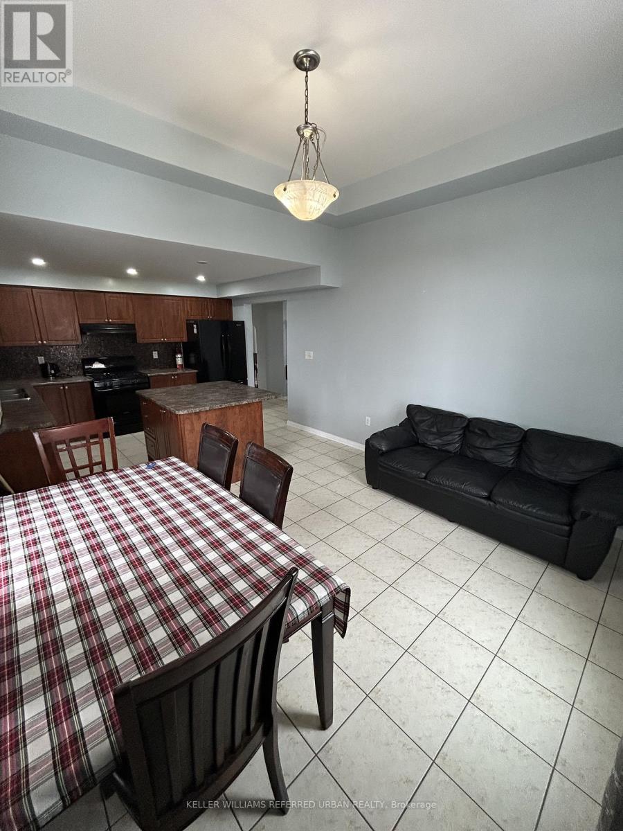A dining room with a checkered tablecloth and a black couch.