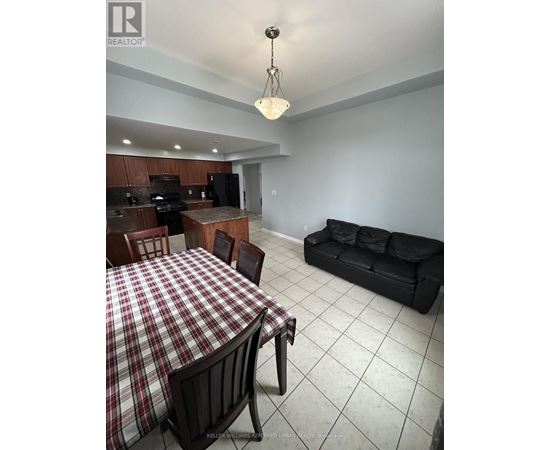 A dining room with a checkered tablecloth and a black couch.
