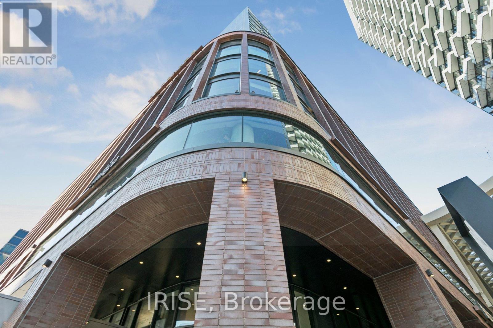 A tall building with a curved facade and a glass entrance.
