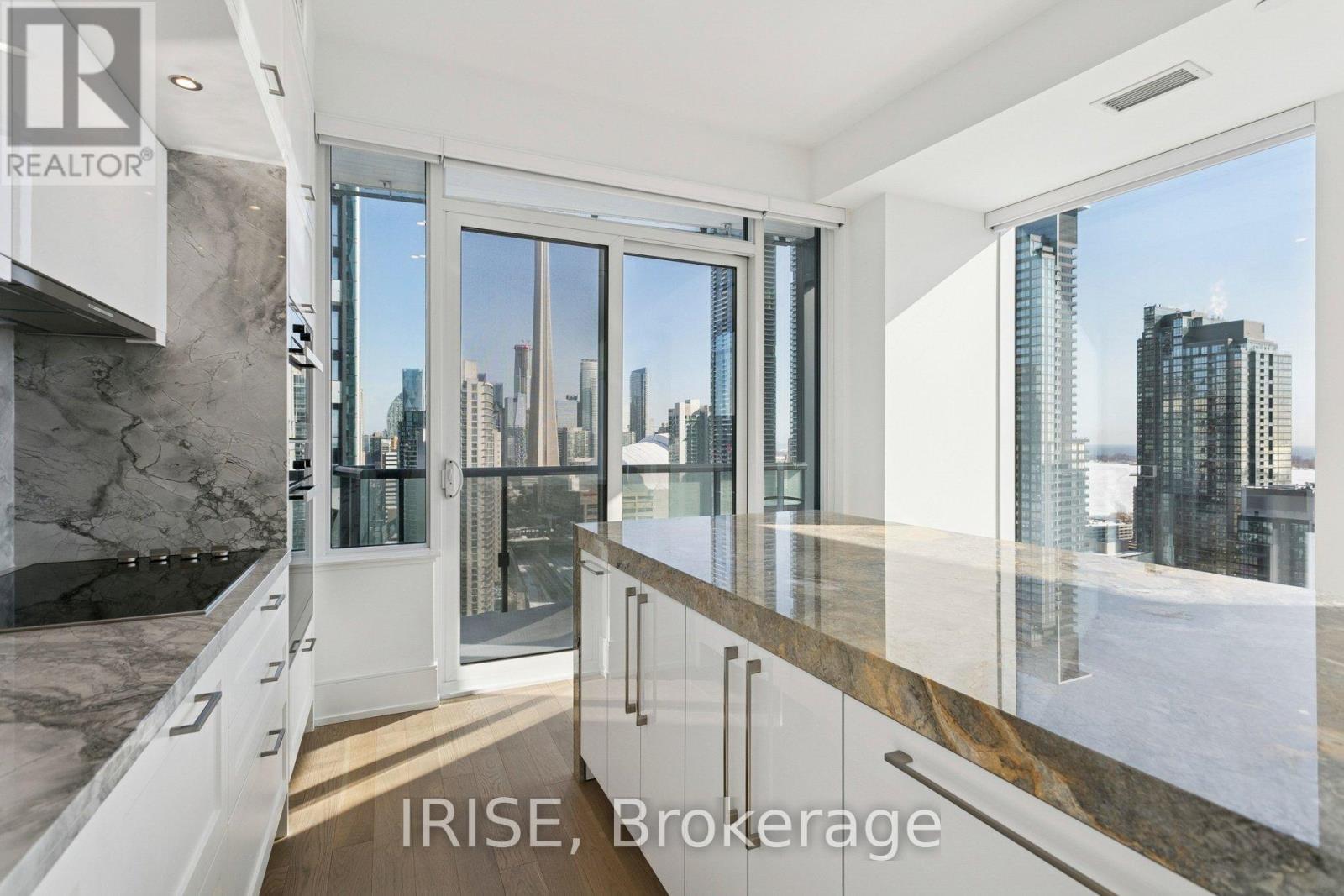 A modern kitchen with marble countertops and a view of the city.