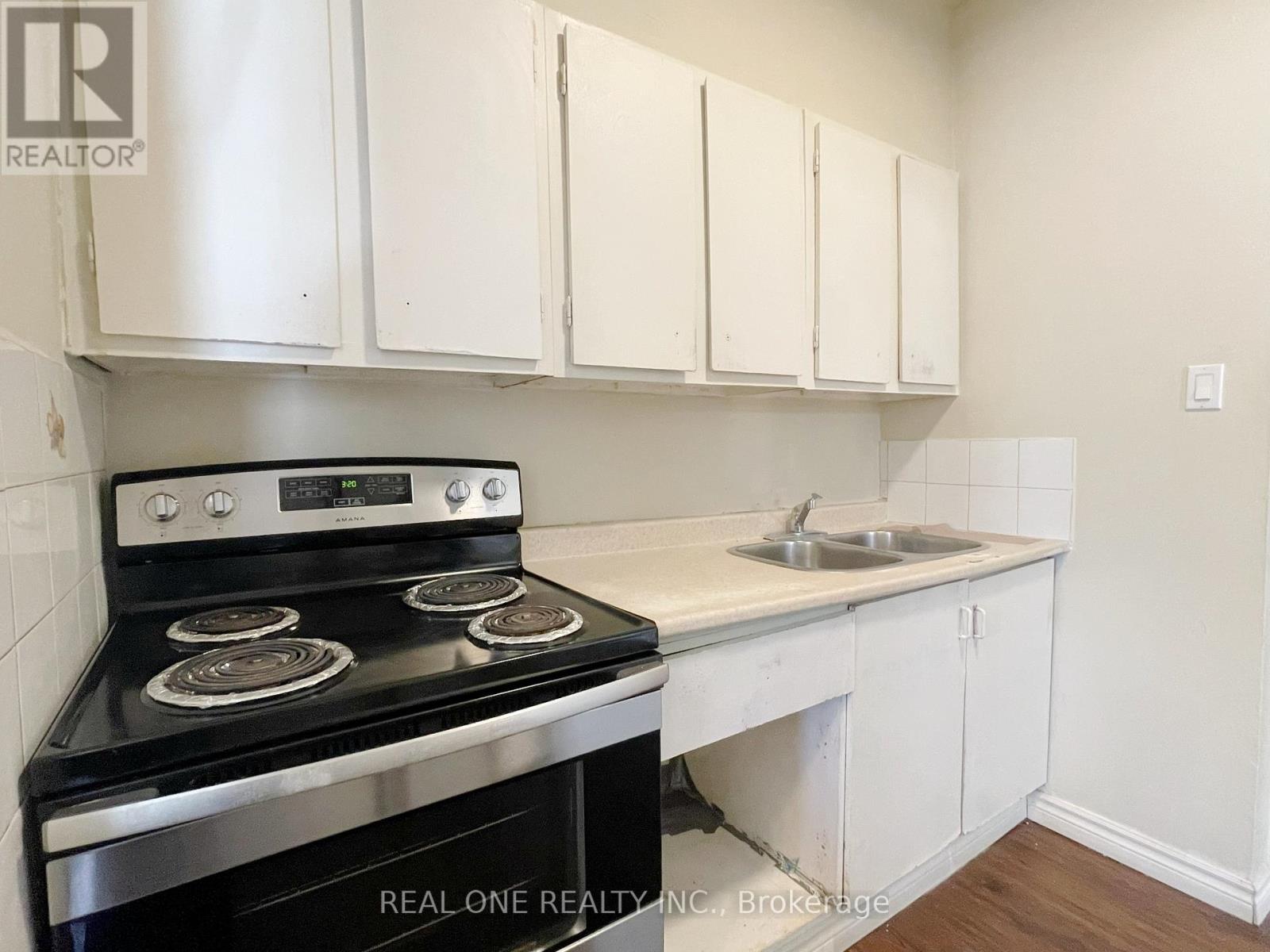 A kitchen with white cabinets and a black stove top oven.