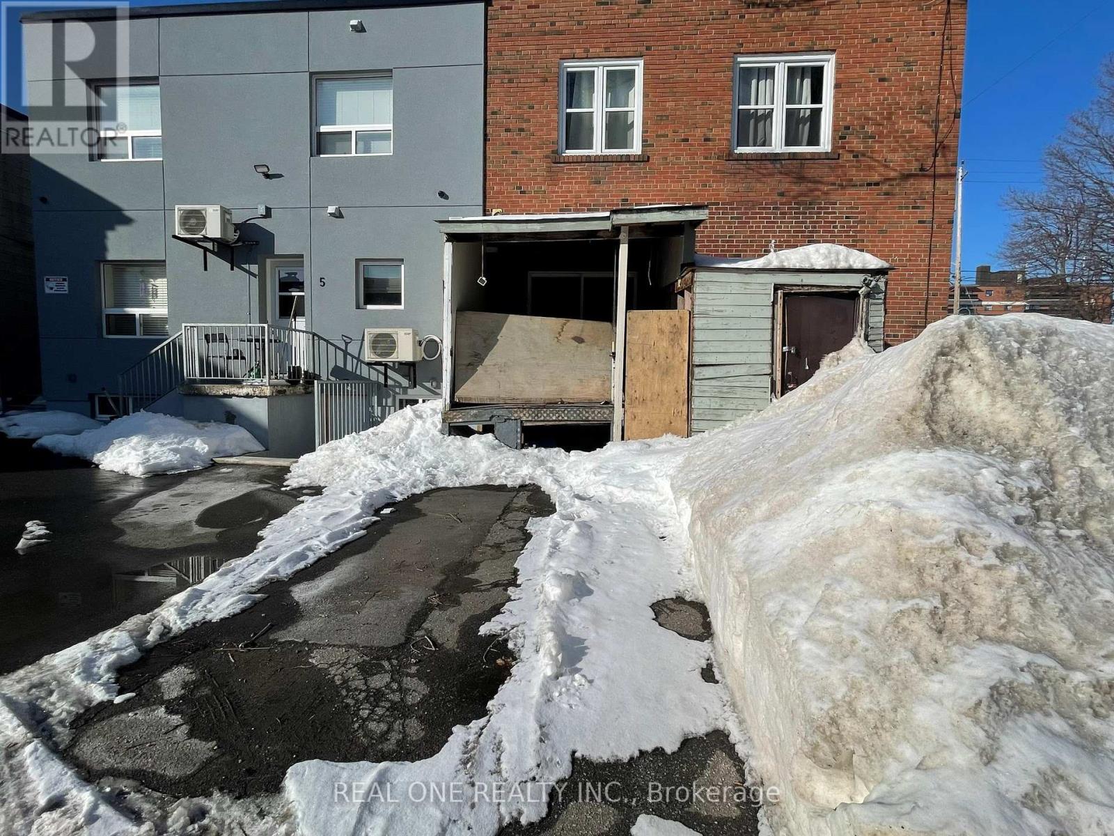 A snow-covered ground with a building in the background.