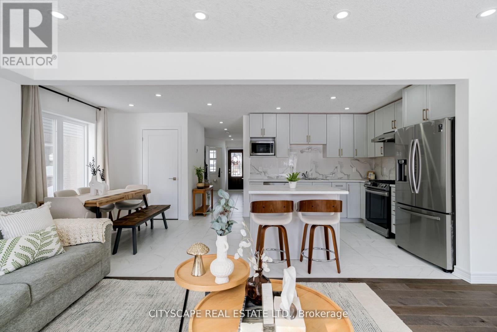 A modern kitchen with a breakfast bar and a dining table with chairs.