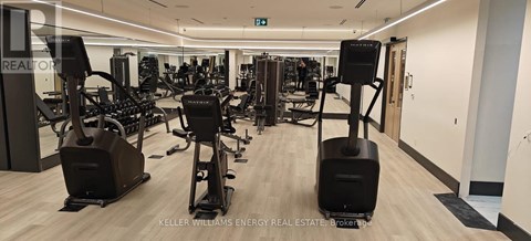 A gym with a variety of equipment including treadmills, weights, and exercise machines.