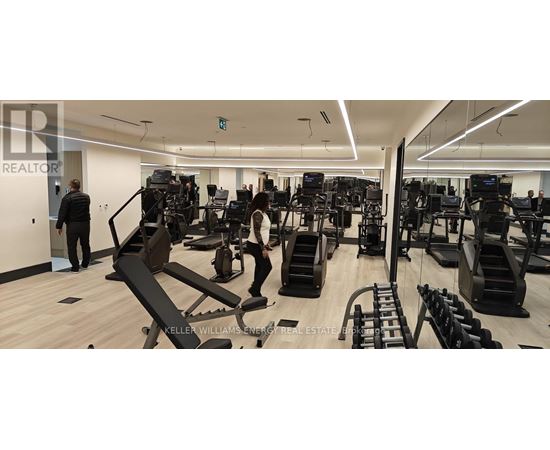 A gym with a variety of equipment and people working out.